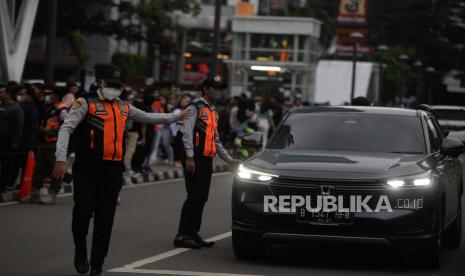 Petugas Dishub mengatur arus lalu lintas saat peragaan busana di Taman Dukuh Atas, Jakarta, Senin (25/7/2022). Petugas gabungan dari Dinas Lingkungan Hidup, Dinas Perhubungan, PPSU dan Satpol PP menjaga kawasan Taman Dukuh Atas karena dijadikan ajang Citayam Fashion Week yang membuat arus lalu lintas terhambat, berserakan sampah dan menimbulkan kerumunan. Republika/Putra M. Akbar