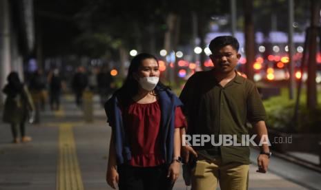 Pekerja berjalan di trotoar kawasan Jalan Jenderal Sudirman, Jakarta, Selasa (17/5/2022). Presiden Joko Widodo melonggarkan kebijakan terkait aturan pemakaian masker dengan  memperbolehkan warga tidak mengenakan masker di luar ruangan apabila tidak dalam kondisi kerumunan menyusul kondisi pandemi COVID-19 di Indonesia saat ini terkendali. 