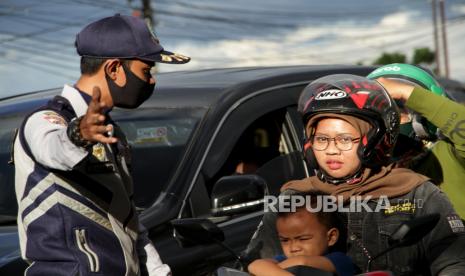 Petugas memberhentikan pengendara yang tidak memakai masker.