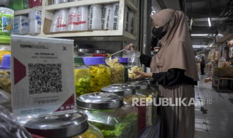 Kode batang QRIS (Quick Response Code Indonesian Standard) yang disediakan di salah satu lapak pedagang di Pasar Kosambi, Kota Bandung, Jawa Barat, Senin (10/7/2023). Bank Indonesia memberlakukan biaya layanan QRIS bagi Penyedia Jasa Pembayaran (PJP) sebesar 0,3 persen dari yang sebelumnya sebesar 0 persen atau gratis. Dalam aturan yang berlaku sejak 1 Juli tersebut, pedagang tidak boleh membebankan balik ke konsumen atau pembeli.