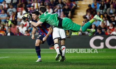 Pesepak bola Barcelona Robert Lewandowski berebut bola dengan kiper Rayo Vallecano Stole Dimitrievski dalam laga lanjutan Liga Spanyol di Campo de Futbol de Vallecas, Madrid, Spanyol, Rabu (26/4/2023). Vallecano mengalahkan Barca dengan skor 2-1. Reuter/Juan Medina