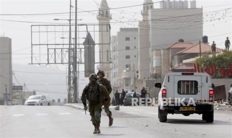 Tentara Israel di lokasi serangan penembakan sehari sebelumnya di kota Hawera di Tepi Barat, 27 Februari 2023. Menurut otoritas Israel, dua orang Israel ditembak dan dibunuh saat mengemudi melalui kota Tepi Barat. Kemudian pada hari yang sama, pemukim Israel membakar rumah dan mobil milik warga Palestina, seorang warga Palestina tewas dan puluhan lainnya luka-luka.