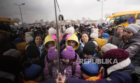  Orang-orang yang melarikan diri dari Ukraina mengantre untuk naik bus di perbatasan di Medyka, Polandia, Jumat, 4 Maret 2022. Lebih dari 1 juta orang telah meninggalkan Ukraina setelah invasi Rusia dalam eksodus pengungsi tercepat di abad ini, kata PBB Kamis.