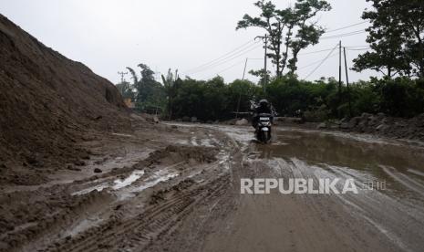 Pengendara sepeda motor melintas di ruas Kebun Kopi Jalan Trans Sulawesi yang terdampak longsor di Kabupaten Donggala, Sulawesi Tengah, Ahad (20/8/2023). Longsor yang disebabkan hujan deras pada Sabtu (19/8) itu membuat arus lalu lintas terhambat dan terpaksa dilakukan mekanisme buka-tutup jalan.  