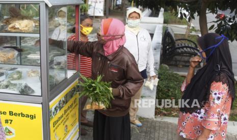 Warga antre mengambil paket kebutuhan pangan gratis melalui program Etalase Berbagi di Jalan Ir. Juanda, Pucang Sawit, Solo, Jawa Tengah, Jumat (27/5/2022). Kegiatan sosial oleh Kelompok Wanita Tani (KWT) Dahlia 9 Pucang Sawit tersebut rutin digelar setiap Jumat dengan menyediakan paket bahan makanan gratis secara swadaya sebagai upaya ketahanan pangan mandiri bagi warga setempat. 