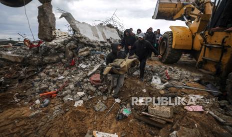 Warga Palestina membawa jenazah seorang anak laki-laki yang ditemukan dari puing-puing rumah yang hancur akibat serangan udara Israel di Deir Al Balah, Jalur Gaza, 29 Januari 2024.