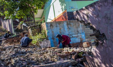 Guru bersama warga membersihkan puing pagar yang roboh pascagempa di SDN Tipar Padalarang, Padalarang, Kabupaten Bandung Barat, Jawa Barat, Senin (16/9/2024). Bangunan pagar sekolah sepanjang 30 meter itu rusak akibat gempa dengan magnitudo 5,3 di Kabupaten Sukabumi pada Ahad (15/9). 