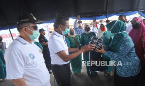 Gubernur Sumatera Barat, Irwan Prayitno (kedua kiri), didampingi Wagub, Nasrul Abit (kiri), memberikan secara simbolis masker untuk dibagikan kepada warga