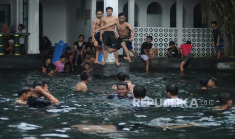 Seorang pengunjung melompat ke dalam air saat tradisi padusan di Umbul Ngabean, Banyudono, Boyolali, Jawa Tengah, Jumat (1/4/2022). Tradisi padusan dilakukan masyarakat setempat guna menyambut bulan ramadhan. 