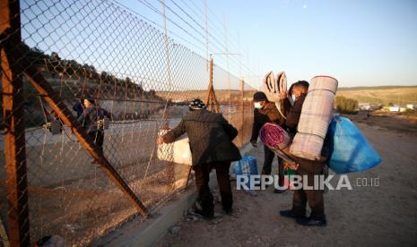 Palestina Mulai Vaksinasi Setelah Dapat 20 Ribu Dosis Vaksin. Warga Palestina melintasi pagar keamanan Israel ke daerah Israel dekat kota Hebron, Tepi Barat, Ahad (31/1/2021). Pekerja Palestina memasuki Israel meskipun ada larangan masuk di tengah kekhawatiran atas penyebaran virus Covid- 19.