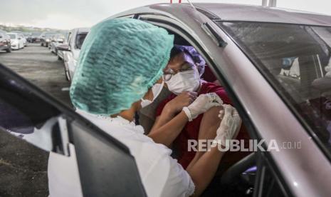 Seorang pria menerima satu dosis vaksin COVID-19 Sinovac di bilik vaksinasi drive-through di Medan, Sumatera Utara, Indonesia, 07 April 2021.