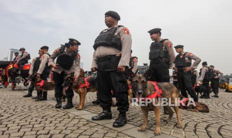 Personel Unit Satwa K9 bersiap mengikuti apel gelar pasukan Operasi Kepolisian Terpusat Ketupat 2024 di Lapangan Silang Monas, Jakarta, Rabu (3/4/2024). Polisi dinilai tak butuh senjata api.