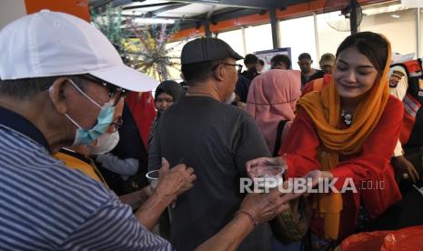 Petugas LRT (Light Rail Transit) (kanan) membagikan makanan khas Betawi ke calon penumpang di Stasiun Dukuh Atas, Jakarta, Sabtu (22/6/2024). Dalam rangka memperingati ulang tahun Jakarta yang ke-497, LRT Jabodebek (Jakarta Bogor Depok Bekasi) menampilkan tarian topeng betawi dan makanan khas betawi yang dibagikan gratis kepada penumpang. 