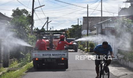 Petugas menyemprotkan cairan disinfektan di kawasan pemukiman, Kota Madiun, Jawa Timur, Rabu (30/12/2020). Pemerintah setempat mengajak masyarakat meningkatkan kewaspadaan dan bersama-sama melakukan pencegahan penularan COVID-19 seiring terus meningkatnya kasus positif COVID-19 hingga daerah yang sebelumnya sempat berstatus zona hijau pertama di Jawa Timur tersebut kini berubah menjadi zona merah. 