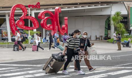 Turis memakai masker saat tiba di Bandara Ngurah Rai di Bali, Indonesia, 05 Januari 2022.