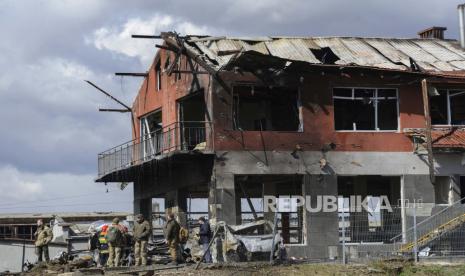 Prajurit Ukraina berdiri di samping toko ban yang hancur akibat serangan udara di Lviv, Ukraina, Senin, 18 April 2022. 