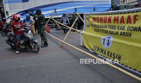 Personel TNI memeriksa sejumlah pengendara motor yang akan melewati titik pemeriksaan di perbatasan Kabupaten Gowa dan Makassar, Sulawesi Selatan, Senin (4/5/2020). Petugas gabungan memperketat akses keluar masuk di Kabupaten Gowa dengan melakukan pemeriksaan kepada warga di hari pertama pelaksanaan Pembatasan Sosial Berskala Besar (PSBB) di Gowa