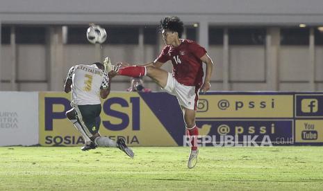 Pesepak bola Timnas U-22 Feby Eka Putra (kanan) berebut bola dengan pesepak bola Tira Persikabo Abduh Lestaluhu dalam laga uji coba di Stadion Madya, Senayan, Jakarta, Jumat (5/3).