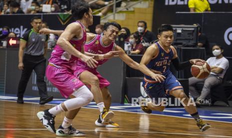 Pebasket Pelita Jaya Bakrie Jakarta Andakara Prastawa Dhyaksa (kanan) berusaha melewati dua pebasket West Bandits Combiphar Solo saat pertandingan Semifinal IBL Tokopedia 2022 di Gor C-Tra Arena, Bandung, Jawa Barat, Ahad (21/8/2022). Pelita Jaya Bakrie Jakarta berhasil melaju ke final usai mengalahkan West Bandits Combiphar Solo dengan skor 86-71. 