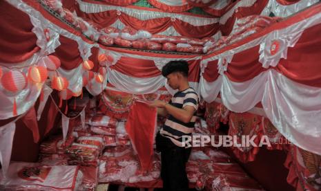 Pedagang merapikan pernak-pernik bernuansa bendera Merah Putih Republik Indonesia. Ada beberapa dekorasi 17 Agustus yang bisa diikuti.