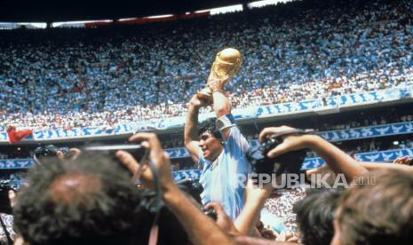  Legenda sepak bola Argentina Diego Armando Maradona mengangkat trofi Piala Dunia FIFA setelah mengalahkan Jerman di stadion Azteca di Mexico City, Meksiko, 29 Juni 1986 (dikeluarkan ulang pada 25 November 2020). Diego Maradona meninggal setelah serangan jantung, laporan media diklaim pada 25 November 2020.