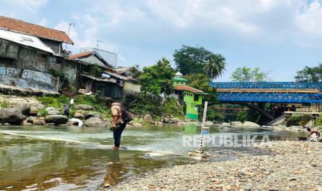 Warga menyeberangi aliran Sungai Ciliwung melalui jembatan darurat, yang melintas antara Kelurahan Baranangsiang Kecamatan Bogor Timur dan Kelurahan Babakan Pasar Kecamatan Bogor Tengah, Kota Bogor, Selasa (14/11/2023). Jembatan darurat ini dibuat oleh warga dari karung berisi batu sejak awal Mei 2023, ketika Jembatan Otista dibangun. 