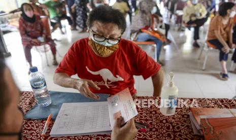 Seorang warga lanjut usia menerima dokumen saat penyaluran bantuan sosial senilai Rp 200 ribu per bulan bagi keluarga penerima manfaat (KPM).