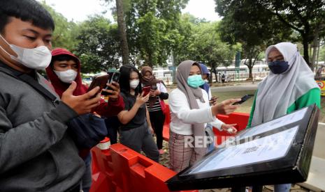  Pengunjung menggunakan ponsel pintar mereka untuk check-in dengan kode QR sebelum memasuki gerbang Kebun Binatang Ragunan di Jakarta, Sabtu (23/10/2021). Pihak berwenang telah membuka kembali salah satu tempat wisata populer di Jakarta, Kebun Binatang Ragunan, setelah ditutup sementara selama darurat virus corona, sebagai bagian dari pembukaan kembali destinasi rekreasi selama pembatasan COVID-19 level 2 atau PPKM (Penegakan Pembatasan Kegiatan Masyarakat) Level 2.