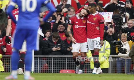 Marcus Rashford dari Manchester United, kanan, merayakan setelah mencetak gol pembuka timnya dengan Bruno Fernandes dari Manchester United pada pertandingan sepak bola Liga Premier Inggris antara Manchester United dan Leicester City di stadion Stamford Bridge di Manchester, Inggris, Ahad, (19/2/2023).