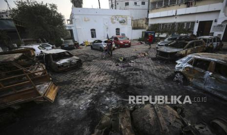 Warga Palestina memeriksa lokasi ledakan di rumah sakit al-Ahli, di Kota Gaza, Rabu, 18 Oktober 2023.