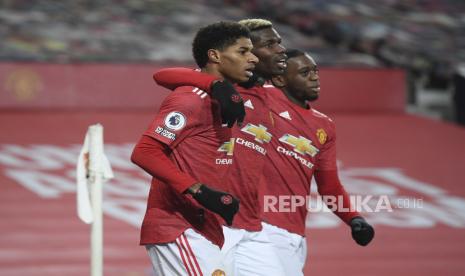 Marcus Rashford dari Manchester United, kiri, merayakan dengan Paul Pogba, tengah, dan Aaron Wan-Bissaka dari Manchester United setelah mencetak gol pembuka selama pertandingan sepak bola Liga Premier Inggris antara Manchester Utd dan Wolverhampton Wanderers di stadion Old Trafford di Manchester, Inggris, Selasa, Des. 29, 2020. 