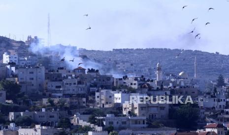 Asap mengepul di atas bangunan tempat tinggal di kamp pengungsi Jenin selama serangan pasukan Israel, dekat kota Jenin di Tepi Barat, 12 Desember 2023.