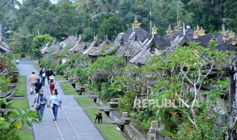 Wisatawan berjalan di sekitar deretan rumah tradisional di Desa Wisata Penglipuran, Bangli, Bali, Jumat (26/2). Jumlah kunjungan wisatawan mancanegara sepanjang (wisman) pada Januari 2021 sebanyak 141,3 ribu kunjungan.