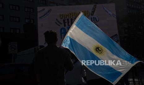 Seseorang memegang bendera Argentina selama kejuaraan barbekyu di Buenos Aires, Argentina, Minggu, 14 Agustus 2022 (ilustrasi). Argentina mencatat inflasi tahun-ke-tahun 98,8 persen pada Januari 2023, setelah memulai tahun ini dengan kenaikan harga bulanan sebesar 6,0 persen, Institut Statistik dan Sensus Nasional (INDEC) melaporkan pada Selasa (14/2/2023).