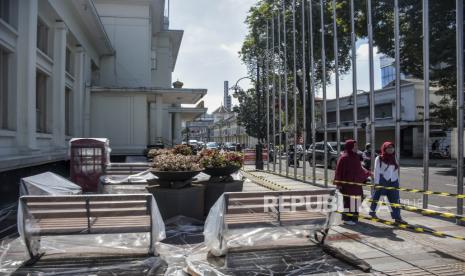 Warga melintas di dekat halaman Gedung Merdeka di Jalan Asia Afrika, Kota Bandung, Jumat (14/10/2022). Pemerintah Provinsi Jawa Barat melakukan renovasi Gedung Merdeka yang merupakan bangunan cagar budaya tempat diselenggarakannya Konferensi Asia Afrika. Renovasi tersebut bertujuan untuk mempertahankan kondisi gedung serta meningkatkan sarana dan prasarana yang ditargetkan rampung pada akhir Desember 2022. Republika/Abdan Syakura