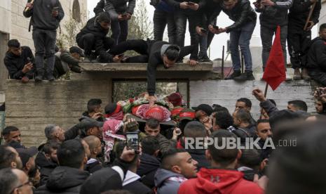  Para pelayat membawa jenazah Omar Khumour Palestina berusia 14 tahun saat pemakamannya di kota Bethlehem, Tepi Barat, Senin, 16 Januari 2023. Kementerian Kesehatan Palestina mengatakan Khumour meninggal setelah kepalanya terkena peluru selama Serangan militer Israel ke kamp pengungsi Dheisha dekat kota Bethlehem. Tentara Israel mengatakan bahwa pasukan memasuki kamp Dheisha dan dibombardir oleh bom molotov dan batu. Dikatakan tentara menanggapi serangan itu dengan tembakan langsung.