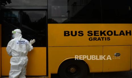 Sopir bus sekolah menutup pintu bus pasien Covid-19 yang akan dibawa menuju Rumah Sakit Darurat Wisma Atlet.