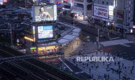 Sejumlah warga menyeberang jalan di kota Shinjuku, Tokyo, Jepang, Ahad (18/7/2021). Anak muda diduga jadi penyebab wabah terbaru karena mereka kumpul hingga larut malam.