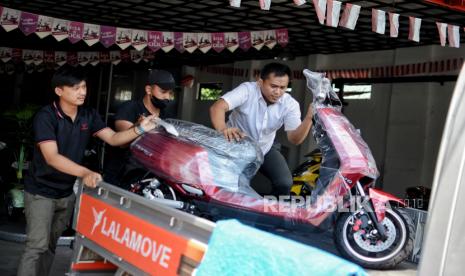 Teknisi mengangkat motor listrik ke mobil pickup di salah satu dealer sepeda motor listrik di Jakarta, Jumat (26/11). Kendaraan listrik saat ini mangalami tren positif. Menurut salah satu marketing dealer uwinfly, penjualan sepeda motor listrik pada bulan Oktober lalu mencapai 2.500 unit untuk wilayah Jabodetabek seiring dengan Peraturan Presiden No. 55/2019 tentang Percepatan Program Kendaraan Bermotor Listrik Berbasis Baterai untuk Transportasi Jalan sebagai upaya menekan emisi karbon di Indonesia. 