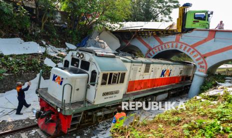 Petugas mengarahkan kereta dengan rute Rangkasbitung-Merak melintas di bawah truk yang menabrak jembatan di Kampung Katupang Teblongan, Cikeusal, Kabupaten Serang, Banten, Sabtu (9/11/2024). Tidak ada korban Jiwa dalam kecelakaan tersebut namun perjalanan kereta rute Rangkasbitung-Merak sempat terganggu. 