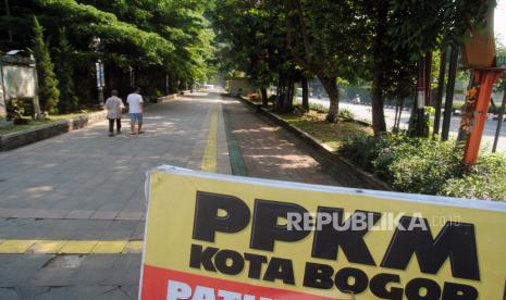 Warga berjalan di jalur pedestrian Kebun Raya Bogor, Jawa Barat, Ahad (27/6/2021). Pemerintah Kota Bogor memberlakukan penutupan jalur pedestrian Kebun Raya Bogor pada akhir pekan sebagai langkah pembatasan mobilitas warga untuk menekan angka kasus COVID-19. 