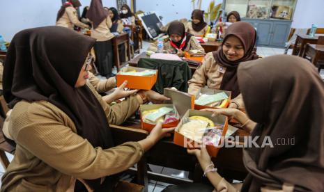 Sejumlah siswa membuka kemasan nasi kotak gratis saat mengikuti sosialisasi dan simulasi program makan siang gratis di SMA Negeri 3 Semarang, Jawa Tengah, Jumat (26/7/2024). Menteri Perdagangan Zulkifli Hasan menyediakan 1.400 porsi susu dan makanan bergizi dengan menu nasi lauk ayam, telur, sayur, dan buah senilai Rp15 ribu per porsi pada simulasi program makan siang gratis untuk pelajar di kota itu. 