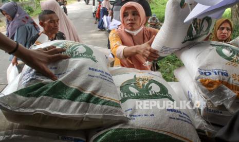 Warga mengambil bantuan sosial pangan beras yang disalurkan di pedalaman Kuta Makmur, Kabupaten Aceh Utara, Aceh, Kamis (16/5/2024).