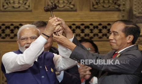 Perdana Menteri India Narendra Modi, kiri, memegang palu bersama Presiden Indonesia Joko Widodo saat upacara serah terima KTT Pemimpin G20, di Nusa Dua, Bali, Indonesia, Rabu, 16 November 2022.