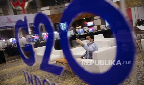 Seorang pria mengambil foto dengan ponselnya di media center, menjelang KTT G20 di Nusa Dua, Bali, Indonesia, 12 November 2022. Bali akan menjadi tuan rumah KTT Kepala Negara dan Pemerintahan Kelompok 20 (G20) ke-17 dari 15 hingga 16 November 2022.