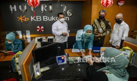 Direktur Utama Bank KB Bukopin Syariah Dery Januar (kedua kiri) bersama Head Region II KB Bukopin Slamet Imam Priadi (kedua kanan) dan Branch Manager KB Bukopin Bogor Irfan Sugiharto (kanan) melihat karyawan melayani nasabah pada peresmian Layanan Syariah Bank Umum di Kantor Bank KB Bukopin Bogor, Jawa Barat, Senin (23/8). PT Bank KB Bukopin Syariah melebarkan ekspansi jaringan Layanan Syariah Bank Umum di Kantor Bank KB Bukopin Bogor, sebagai bentuk kontribusi dalam meningkatkan pelayanan kepada masyarakat. Adapun layanan produk yang ditawarkan untuk masyarakat, yaitu produk pendanaan, layanan pembiayaan dan produk jasa (service). 