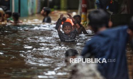 Anak-anak bermain saat banjir melanda permukiman warga di Kebon Pala, Kelurahan Kampung Melayu, Jatinegara, Jakarta Timur, Kamis (28/11/2024).