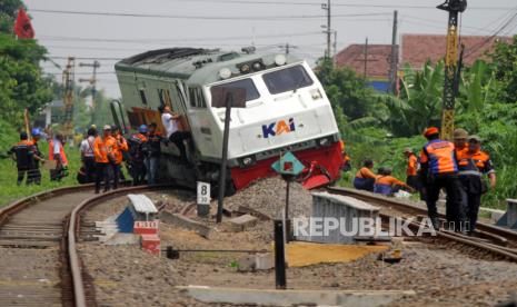 Petugas berada di samping kereta api yang anjlok di emplasemen Stasiun Tanggulangin, Sidoarjo, Jawa Timur, Ahad (14/1/2024). Anjloknya KA Pandalungan relasi Gambir-Surabaya-Jember tersebut belum diketahui penyebabnya. 