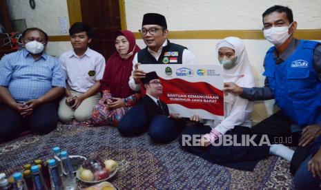 Gubernur Jawa Barat Ridwan Kamil (berpeci) secara simbolis menyerahkan bantuan kemanusiaan kepada penyandang disabilitas Raisya Putri Fathimah Azahra di Jalan Pamoyanan, Cicendo, Kota Bandung, Kamis (17/11). Kegiatan kerjasama antara Pemprov Jawa Barat, Jabar Quick Response dan Rumah Yatim ini merupakan bentuk kepedulian Pemprov Jawa Barat terhadap warga, khususnya yang membutuhkan bantuan.