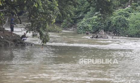 Sejumlah warga memancing ikan di aliran Kali Cikarang, Kabupaten Bekasi, Jawa Barat, Ahad (31/1/2021). Badan Penanggulangan Bencana Daerah (BPBD) Kabupaten Bekasi mengimbau warga yang tinggal di sekitar aliran kali untuk waspada banjir akibat kenaikan debit air Kali Cikarang karena curah hujan tinggi. 